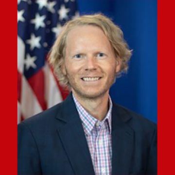 Headshot of Michael Cavey against a red background