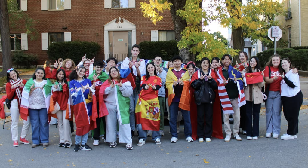 ISS students posing with flags at the homecoming parade