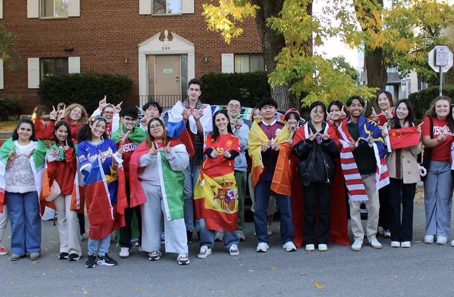 ISS students posing with flags at the homecoming parade